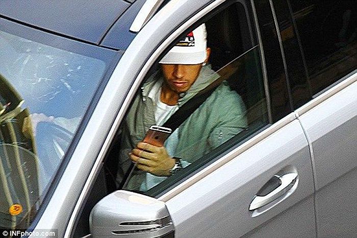 Lewis Hamilton driving and playing with his phone