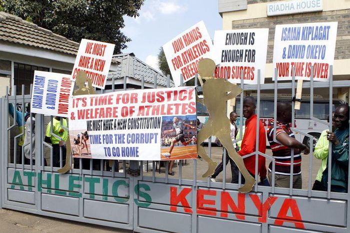 Protesting Kenyan athletes place placards behind closed gates at Riadha House the Athletic Kenya (AK) Headquarters in capital Nairobi November 23, 2015. REUTERS/Noor Khamis