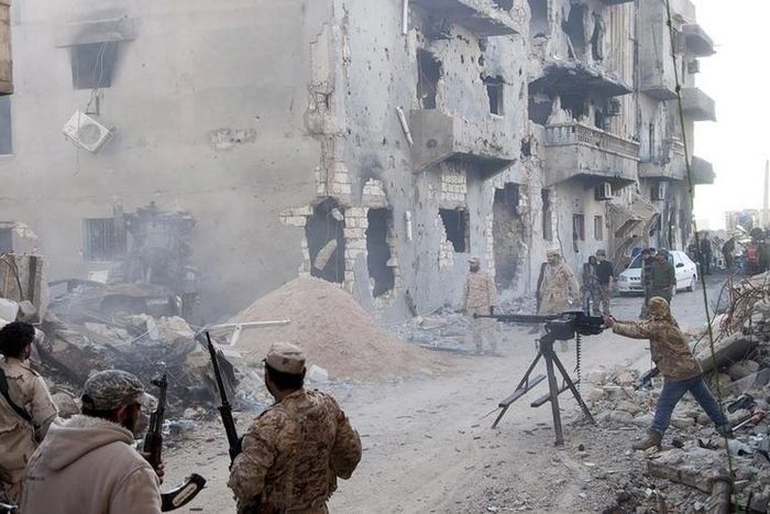 Members of the Libyan pro-government forces, backed by the locals, with weapons are seen during clashes in the streets with Shura Council of Libyan Revolutionaries, an alliance of former anti-Gaddafi rebels who have joined forces with Islamist group An...