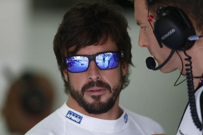 McLaren's Fernando Alonso (L) speaks to a crew member before practice for the Malaysian Grand Prix. Reuters / Olivia Harris