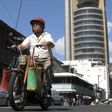 A Mauritian man rides his motorbike past Mauritius' central bank in the capital in a file photo. REUTERS/Ed Harris