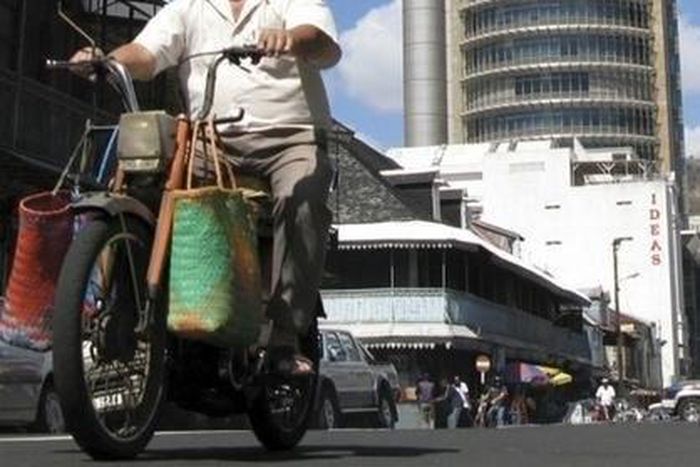 A Mauritian man rides his motorbike past Mauritius' central bank in the capital in a file photo. REUTERS/Ed Harris
