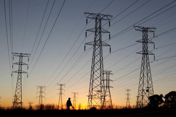 A man walks past electricity pylons as he returns from work in Soweto, outside Johannesburg May 15, 2012. REUTERS/Siphiwe Sibeko