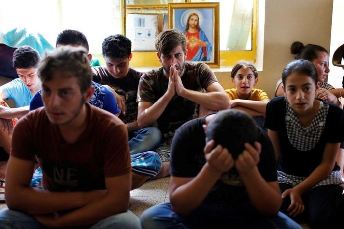 Displaced Iraqi Christians who fled from Islamic State militants in Mosul, pray at a school acting as a refugee camp in Erbil, Iraq, September 6, 2014.