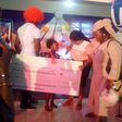 Dayo Amusa presenting a cheque of N100,000 to a winner at her event for the children
