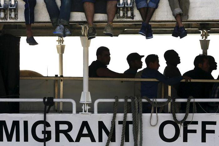 Migrants wait to disembark from the Migrant Offshore Aid Station (MOAS) ship MV Phoenix in the Sicilian harbour of Messina, Italy July 15, 2015. REUTERS/Antonio Parrinello