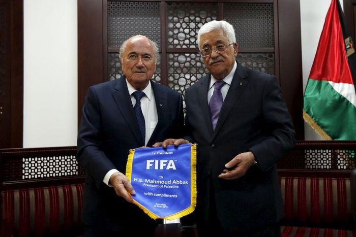 Palestinian President Mahmoud Abbas (R) receives a gift from FIFA chief Sepp Blatter during their meeting in the West Bank city of Ramallah May 20, 2015.   REUTERS/Mohamad Torokman