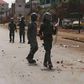 Security forces walk down a street filled with debris after protests in Conakry, Guinea, May 7, 2015. Youths in Guinea's capital blocked roads with burning tyres and clashed with security forces on Thursday, raising pressure on President Alpha Conde ah...