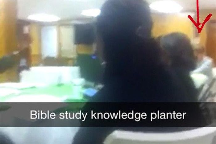 A screenshot from the video showing the killer, Dylann Roof at the far end.