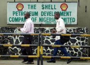 People walk past the Dutch oil giant Shell's sign board in Port Harcourt in the volatile Niger delta region of Nigeria, in a file photo. REUTERS/George Esiri
