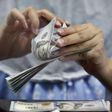 A teller counts U.S. dollars at a money changer in Jakarta, Indonesia May 18, 2015. REUTERS/Nyimas Laula