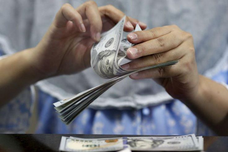 A teller counts U.S. dollars at a money changer in Jakarta, Indonesia May 18, 2015. REUTERS/Nyimas Laula