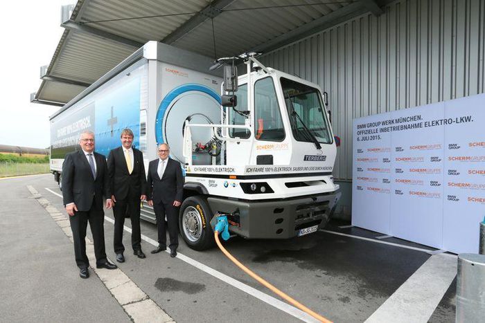 Officials of both comanies with the all-electric truck