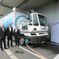 Officials of both comanies with the all-electric truck