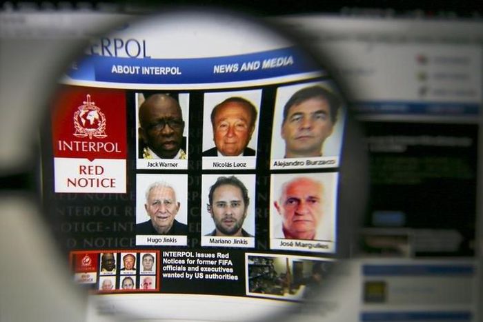 The homepage of the Interpol website is seen through a magnifying glass in this picture illustration taken in Berlin, Germany June 3, 2015. REUTERS/Pawel Kopczynski