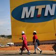 Protesters walk past an MTN logo during a strike of about 2,000 MTN workers outside the company's headquarters in Johannesburg, May 20 2015. REUTERS/Siphiwe Sibeko