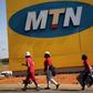 Protesters walk past an MTN logo during a strike of about 2,000 MTN workers outside the company's headquarters in Johannesburg, May 20 2015. REUTERS/Siphiwe Sibeko