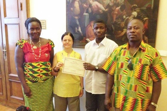 An official of the Santa Lucia education directorate (second left) presenting a certificate of merit to Master Emmanuel Sarpong Agyemang. Flanking them are the parents of Master Agyemang