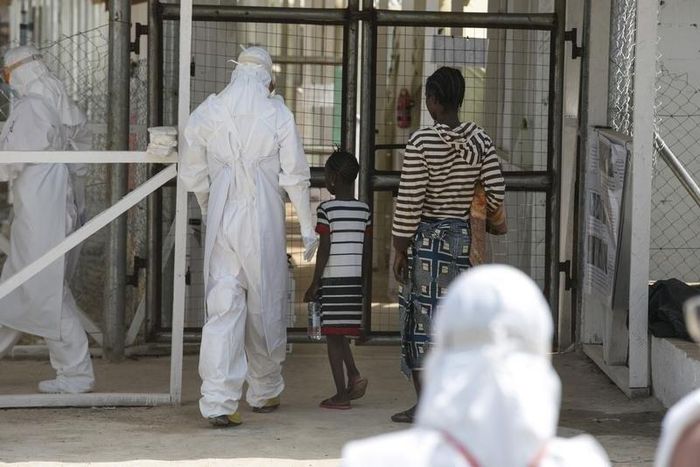 A health worker escorts newly admitted Ebola patients into the Kerry town Ebola treatment centre outside Freetown December 22, 2014. 
REUTERS/Baz Ratner (SIERRA LEONE - Tags: HEALTH POLITICS)