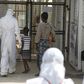 A health worker escorts newly admitted Ebola patients into the Kerry town Ebola treatment centre outside Freetown December 22, 2014. 
REUTERS/Baz Ratner (SIERRA LEONE - Tags: HEALTH POLITICS)