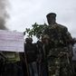 Soldiers, standing near a sign with a message against Burundian President Pierre Nkurunziza's plan to run for a third term in office, talk to protesters as they barricade a road in Bujumbura, May 8, 2015. REUTERS/Jean Pierre Aime Harerimana