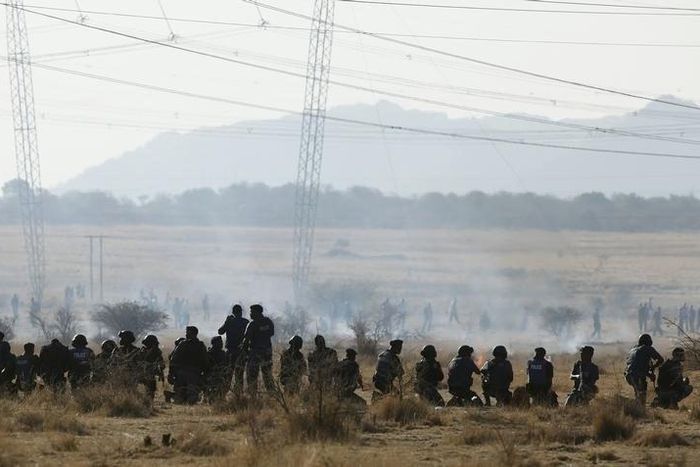 Policemen fire at striking miners outside a South African mine in Rustenburg, 100 km (62 miles) northwest of Johannesburg, August 16, 2012.