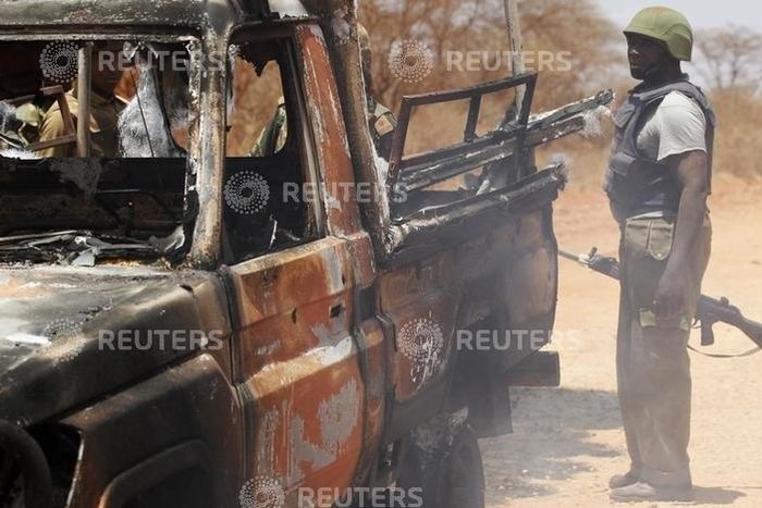 Security officers guard a police car, which was burnt during an attack on a convoy escorting Mandera governor Ali Roba, outside Mandera town, near Kenya's border with Somalia and Ethiopia, March 13, 2015.   REUTERS/Stringer