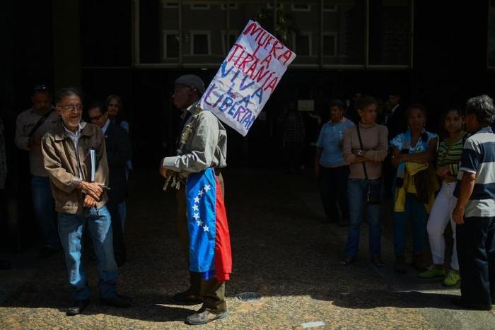 A man holds a placard reading "Die Tyranny / Long Live Freedom" outside the National Assembly building in Caracas on January 5, 2019