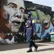 A security guard walks past a wall mural depicting U.S. President Barack Obama outside the Go-Down Art Centre in Kenya's capital Nairobi, July 17, 2015.    REUTERS/Thomas Mukoya