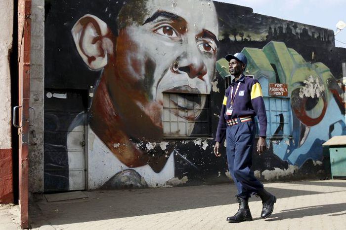 A security guard walks past a wall mural depicting U.S. President Barack Obama outside the Go-Down Art Centre in Kenya's capital Nairobi, July 17, 2015.    REUTERS/Thomas Mukoya