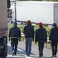 Migrants walk near trucks blocked on a road which leads to the Channel Tunnel terminal in Coquelles near Calais, northern France, July 1, 2015.    REUTERS/Vincent Kessler
