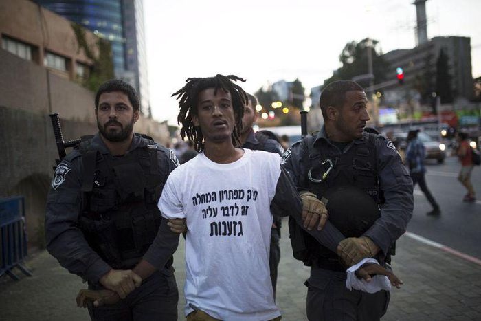 Israeli policemen detain a protestor during an anti-racism protest in Tel Aviv June 3, 2015. REUTERS/Amir Cohen