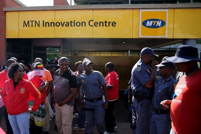 Police officers keep watch during a strike of MTN workers outside the company's headquarters in Johannesburg May 20, 2015. REUTERS/Siphiwe Sibeko