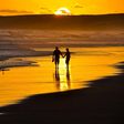 Couple taking a romantic walk on the beach at Sunset