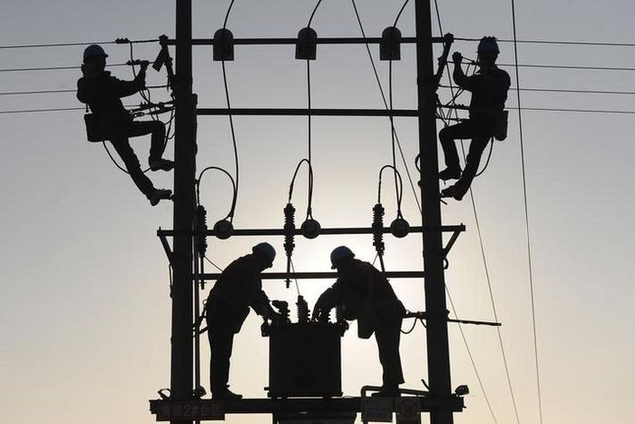Labourers work on an electricity pylon in Huangni village of Chuzhou, Anhui province March 17, 2014. REUTERS/China Daily