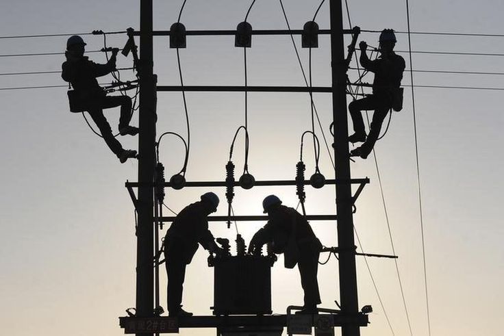 Labourers work on an electricity pylon in Huangni village of Chuzhou, Anhui province March 17, 2014. REUTERS/China Daily