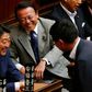 Financial Minister Taro Aso, center, and Japanese Prime Minister Shinzo Abe, left, share a light moment during a plenary session at the lower house in Tokyo, Thursday, July 16, 2015.