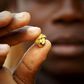 A gold prospector holds a gold nugget between his fingers at a gold mine near the village of Gamina in western Ivory Coast, March 16, 2015. REUTERS/Luc Gnago
