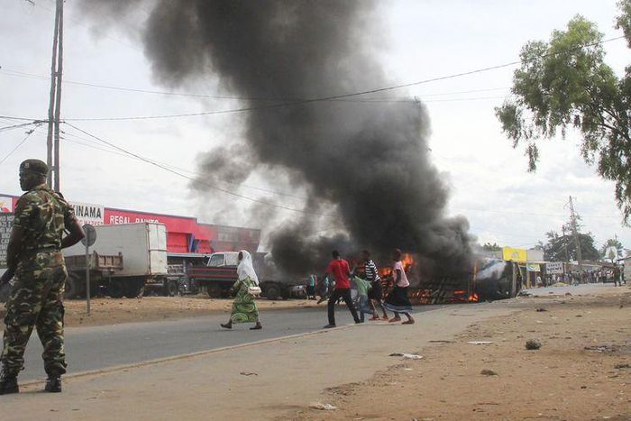 Soldiers stand near a burning barricade during demonstrations by protesters against the ruling CNDD-FDD party's decision to allow Burundian President Pierre Nkurunziza to run for a third five-year term in office, in Bujumbura, May 7, 2015. REUTERS/Jean...