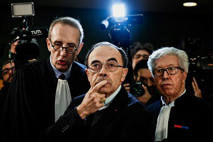 Cardinal Barbarin flanked by lawyers as he arrives in court in Lyon