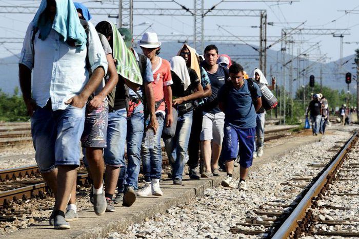 Migrants walk towards the train station in Gevgelija July 19, 2015. REUTERS/Ognen Teofilovski