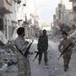 Members of Libyan pro-government forces, backed by the locals, walk with weapons during clashes in the streets with Shura Council of Libyan Revolutionaries, an alliance of former anti-Gaddafi rebels who have joined forces with Islamist group Ansar al-S...