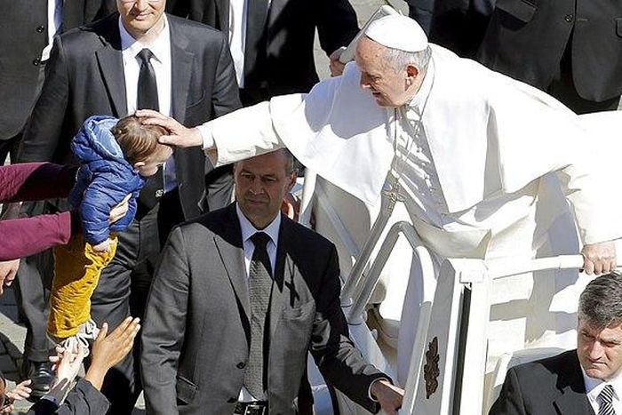 The Pope blesses a baby at the end of Palm Sunday Mass