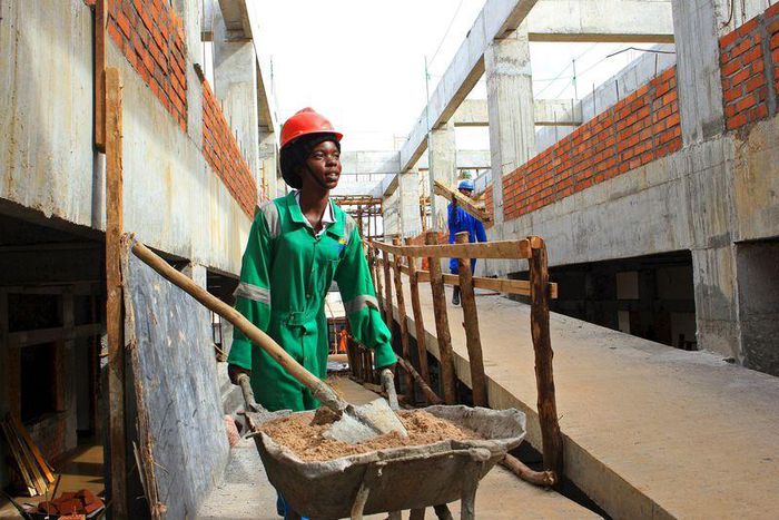 A woman working in a construction site moves building material in a section of a new hospital in Hoima town, Uganda April 27, 2015. Before the discovery of large amounts of oil in Lake Albert, Hoima was a forlorn and remote town in Western Uganda, whos...
