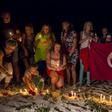 People place lit candles in the sand in front of the Imperial Marhaba Hotel, where a gunman had carried out an attack, in Sousse, Tunisia, June 28, 2015. REUTERS/Zohra Bensemra