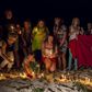 People place lit candles in the sand in front of the Imperial Marhaba Hotel, where a gunman had carried out an attack, in Sousse, Tunisia, June 28, 2015. REUTERS/Zohra Bensemra