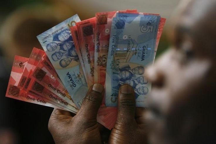 A man holds Ghana's cedi notes in Accra