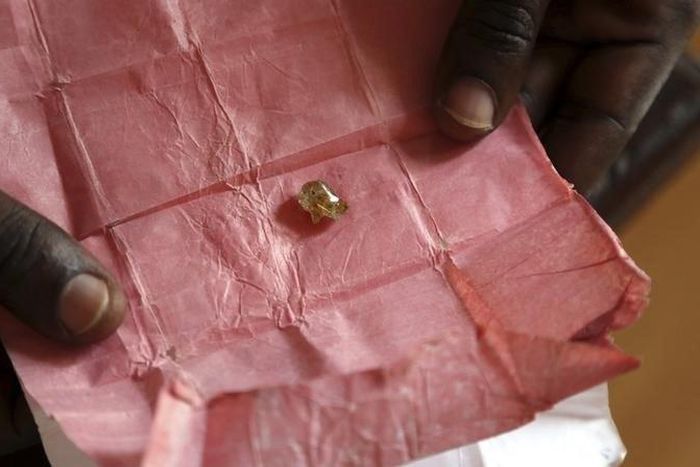 A man displays a rough diamond, from the Boda region, for sale in Bangui May 1, 2014.   REUTERS/Emmanuel Braun