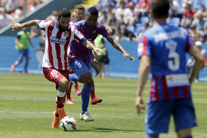 Atletico Madrid's Arda Turan (L) and Levante's Kalu Uche fight for the ball during their Spanish first division soccer match at the Ciudad de Valencia stadium in Valencia, Spain, May 10, 2015. REUTERS/Heino Kalis