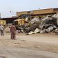 Men watch as bulldozers remove debris in front of a damaged building after a suicide car bomber blew himself up at a checkpoint in Dafniya outside Mistrata, Libya May 31, 2015. REUTERS/Stringer